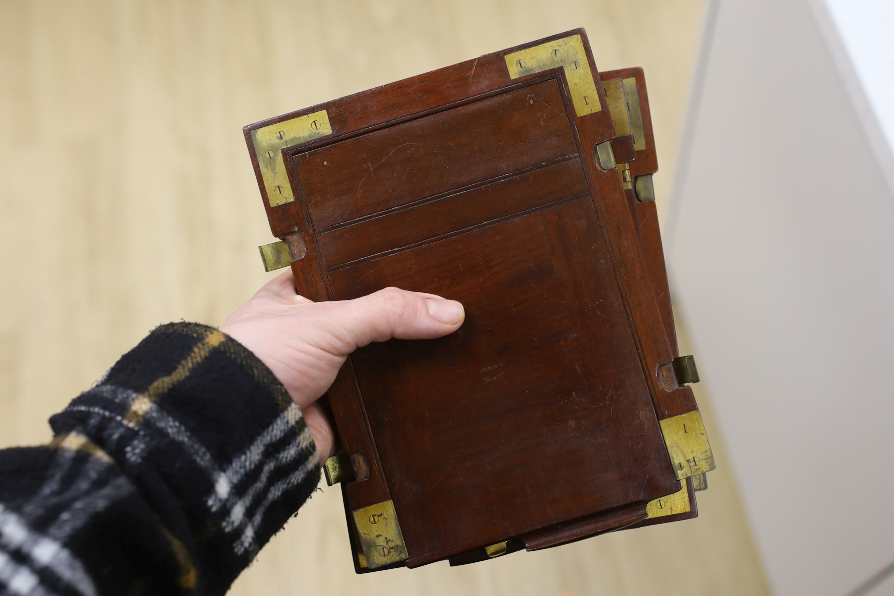 An early 20th century half plate camera by Sands, Hunter & Co. 37 Bedford Street, Strand, London WC, mahogany and brass frame, body 21 x 20cm, in the original leather case, also containing a Taylor, Taylor & Hobson Ltd.